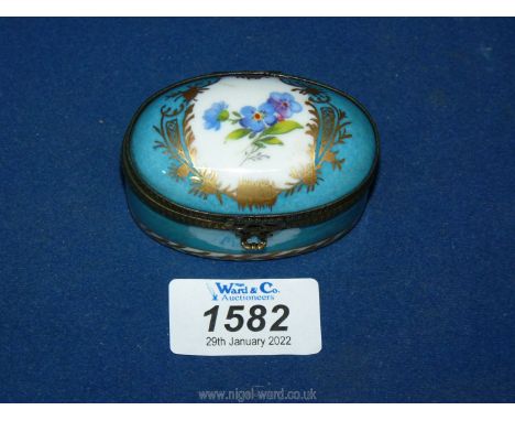 A blue oval ceramic box with gold and floral design, 2 3/4" diameter x 1 1/2" tall.