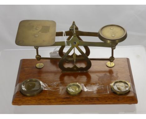 A Set of Brass and Oak Letter Scales, complete with weights.