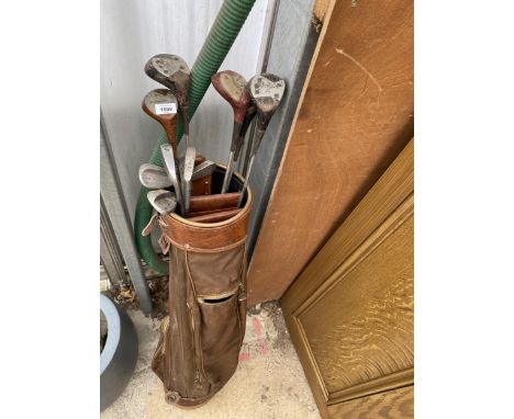 A VINTAGE GOLF BAG AND AN ASSORTMENT OF VINTAGE GOLF CLUBS 
