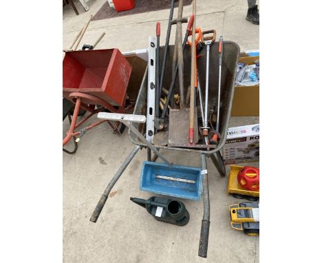 A METAL WHEEL BARROW AND AN ASSORTMENT OF GARDEN TOOLS TO INCLUDE A SEEDER AND SPADES ETC 