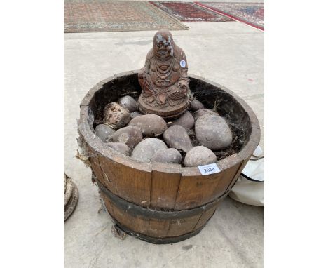 A HALF BARREL PLANTER AND A RECONSTITUTED STONE GARDEN FIGURE 