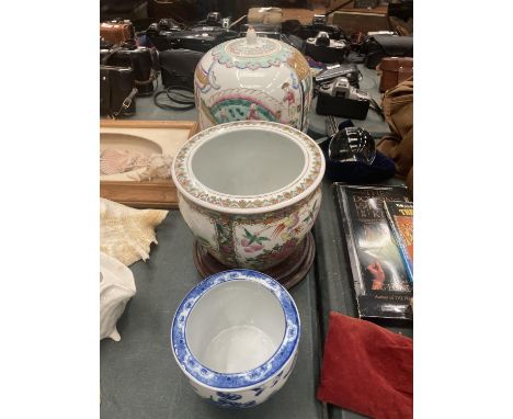 A LARGE ORIENTAL JAR WITH LID, A LARGE PLANTER WITH WOODEN STAND AND A SMALLER BLUE AND WHITE PLANTER.  ALL PROCEEDS TO GO TO