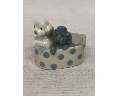 A NAO FIGURE OF TWO DOGS IN A BASKET 