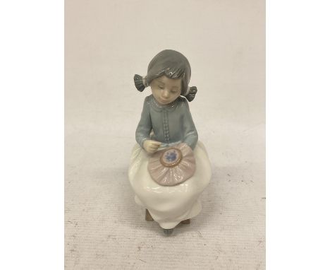 A NAO FIGURINE OF A GIRL SEWING 