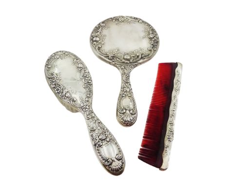 American silver mounted three piece dressing table set, comprising hand mirror, hairbrush and comb, each embossed with flower