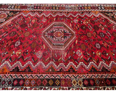 VINTAGE IRANIAN WOOL CARPET - red ground with traditional central motif and multi-bordered edge, 270 x 178cms