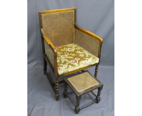 VINTAGE BERGERE ARMCHAIR on bobbin front supports and a similarly styled footstool, 95cms H, 60.5cms W, 53.5cms D the seat