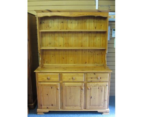 MODERN PINE DRESSER with two shelf rack over a base arrangement of three drawers and three cupboard doors, on corner bracket 