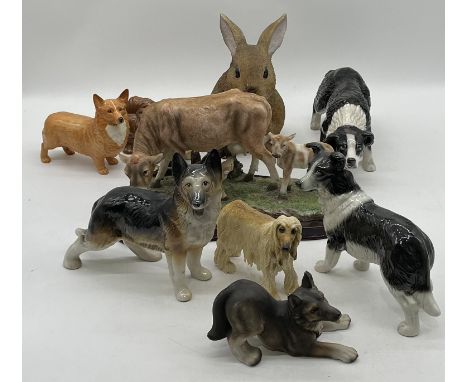 A collection of dog figurines including a Beswick Corgi, Melba Ware etc along with a Juliana figure group of a cow with calve