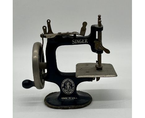 A miniature vintage Singer sewing machine.