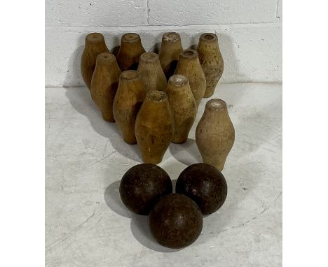 A vintage set of eleven wooden skittles with three wooden balls