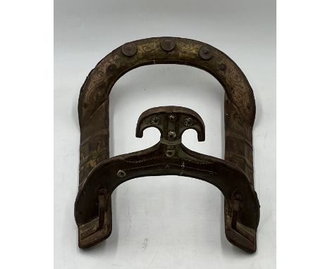 An antique eastern goat saddle with brass detailing