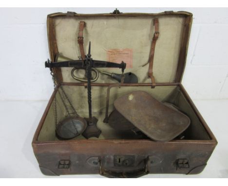 A vintage leather suitcase containing two sets of scales and a brass car horn (A/F)