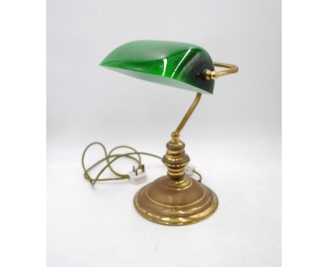 A brass bankers lamp with green shade