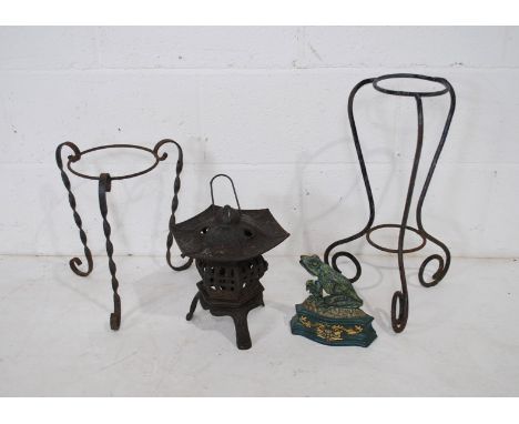 Two wrought iron plant stands, along with a cast iron garden pagoda lantern and a frog doorstop 