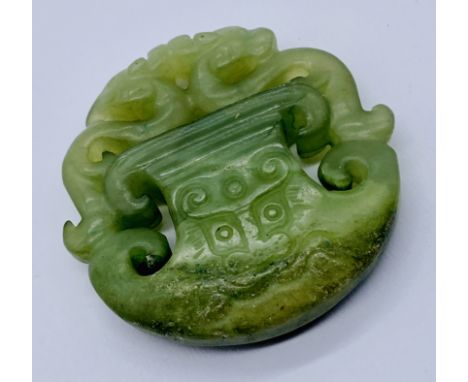 A carved jade pendant depicting dragons, 5.25 cm diameter