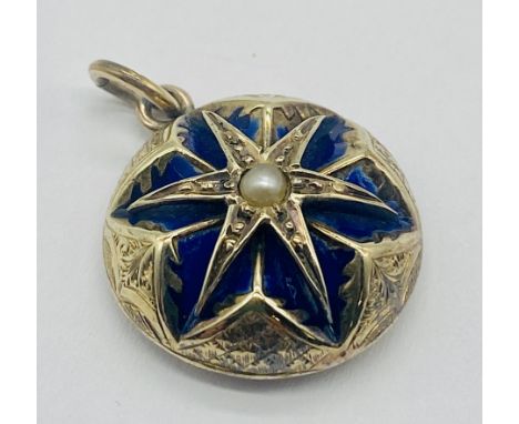 An unmarked gold memorial pendant with enamelled detailing around a central seed pearl