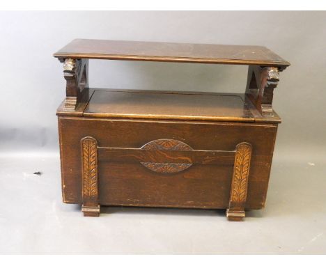 An oak monk's bench with tilt top and carved lion decoration, 35½'' x 15'', 27'' high 