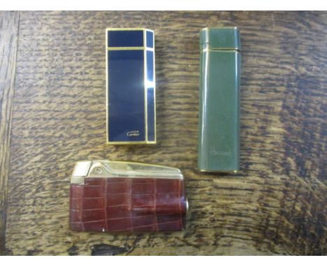 A group of lighters to include a Must de Cartier blue enamel lighter, a Merumari Harrods lighter, and Ronson leather clad lig