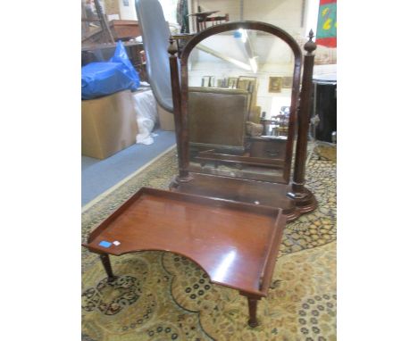 A large Victorian mahogany swing mirror with arched top, flanked by octagonal columns and carved finials, on a serpentine fro