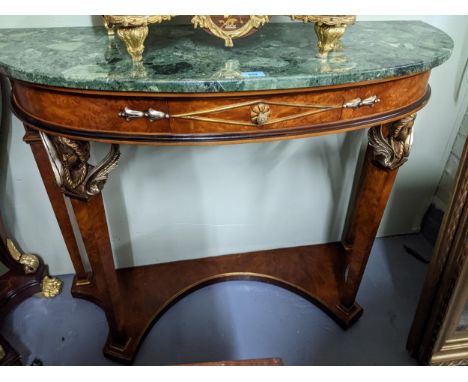 An Italian demi lune walnut console table with ebonized and gilt highlights, green variegated marble top, above a central dra