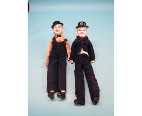 A pair of porcelain dolls, Laurel and Hardy, each with ceramic lower limbs and fully clothed, 21in.