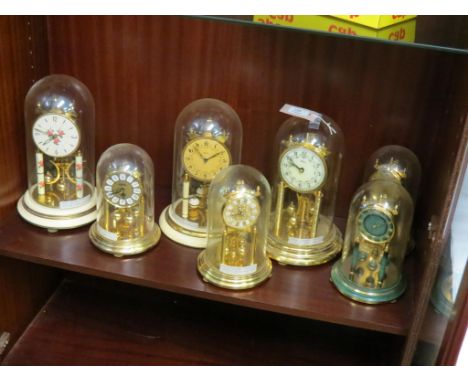 Seven various long-duration mantel clocks, each under glass - perspex dome