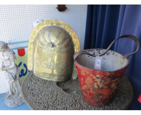 An 18th century French embossed brass fireguard, 17in. and a 19th century leather fire bucket, painted with Royal Arms 