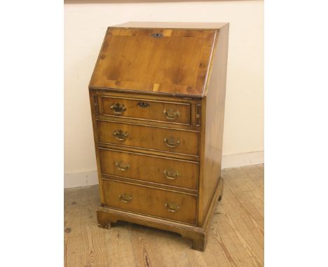 A reproduction yew-veneered lady's bureau, fall-front enclosing fittings, four drawers beneath, bracket feet, 1ft. 8in.