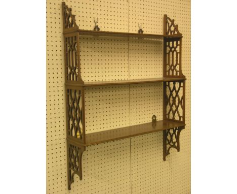 A Chippendale-style mahogany range of three shelves, open lattice sides, 2ft.