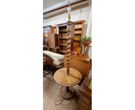 A 20th Century oak standard lamp with barley twist stem and wine table surface, set on turned pillar and carved circular base