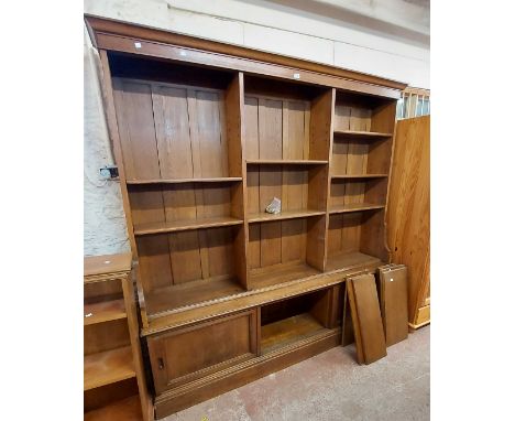 A 2.04m vintage oak two part library bookcase with moulded cornice and adjustable open shelves over a base enclosed by slidin
