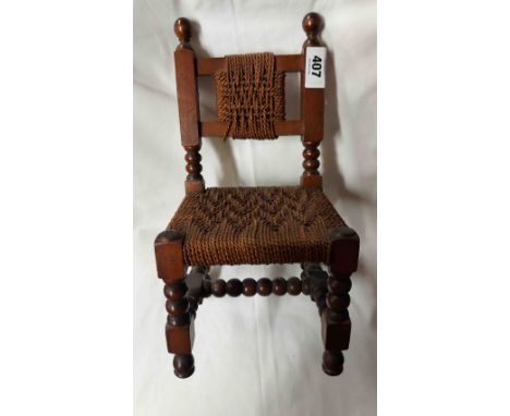 A vintage miniature oak framed chair with woven seagrass panelled back and seat, set on bobbin supports