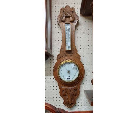 A 20th Century carved oak framed banjo barometer/thermometer with printed dial and aneroid works