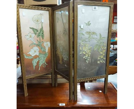A vintage three fold low screen with floral embroidered canvas panels under glass and reeded frame