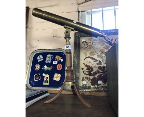 A modern brass telescope, set on turned wood tripod stand