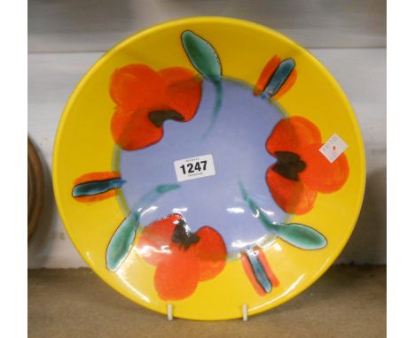A Poole Pottery dish with stylised painted flowerheads in a bold colour palette