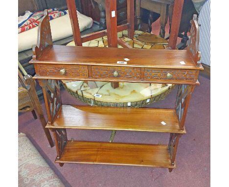 A 66.5cm eastern hardwood wall mounted three shelf open bookcase with three drawers to base, blind fretwork decoration and la