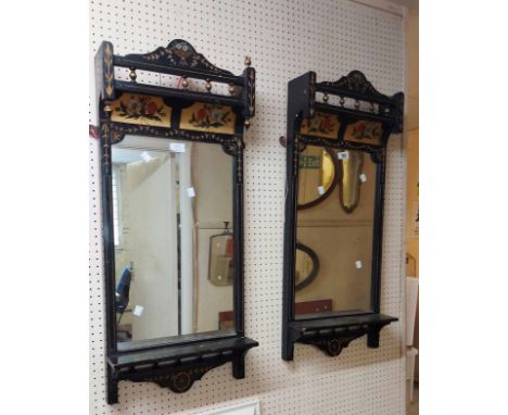 A pair of decorated ebonised framed Aesthetic Movement pier mirrors with hand painted floral panels and gilded incised border