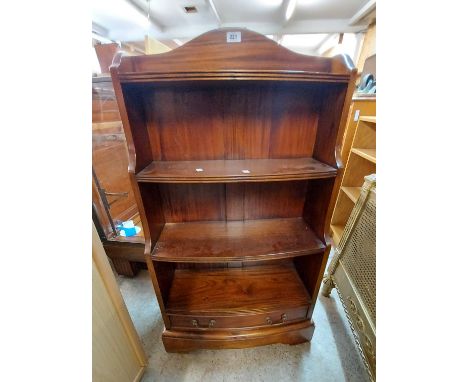 A 60cm Eastern hardwood four shelf open waterfall bookcase with slightly bow front and drawer under, set on bracket base