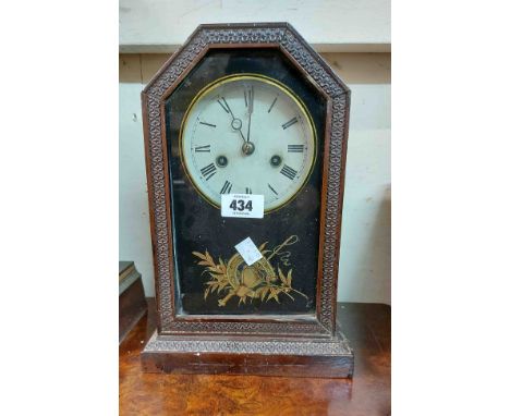 An antique American stained wood cased shelf clock with decorative glazed panel door and bell striking movement