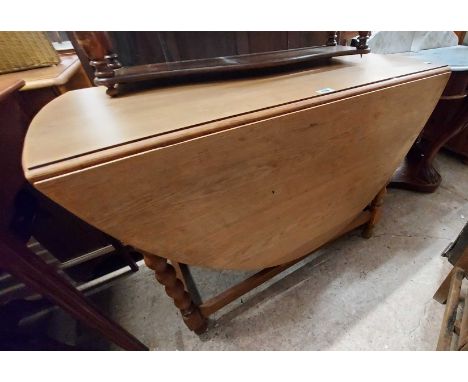 A 1.04m stripped oak gateleg table, set on bobbin turned supports