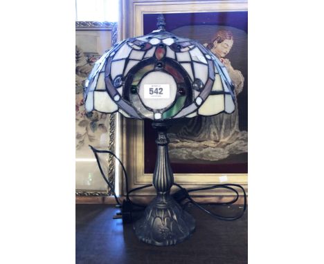 A modern cast metal table lamp with Tiffany style glass shade