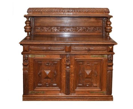 Late 19th/early 20th Century carved oak buffet, the raised back having an open shelf supported by turned pillars, the base wi