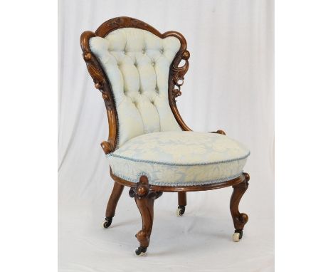 Victorian walnut framed salon chair having carved cresting, raised on cabriole supports fitted ceramic casters, upholstered i