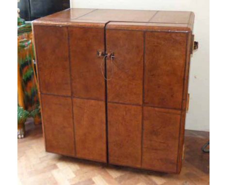 Leather bound two door cabinet in the form of travelling trunk. Condition Report: see terms and conditions.