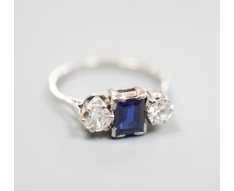 A white metal (stamped plat), sapphire and diamond set three stone ring, size K, gross weight 3.6 grams.