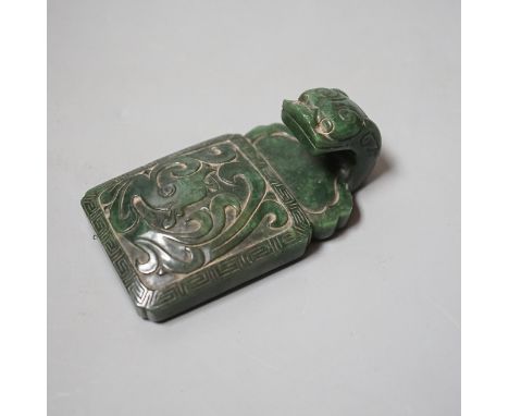 A Chinese spinach green jade belt hook, 19th century, in archaistic style, carved in relief with a chi-dragon, with a dragon 