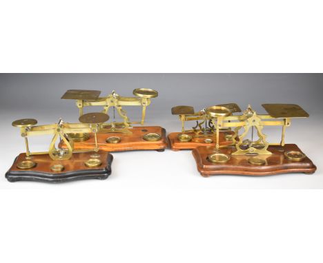 Four sets of brass postage scales, one marked STS, another with rates to pan, length of longest 25cm