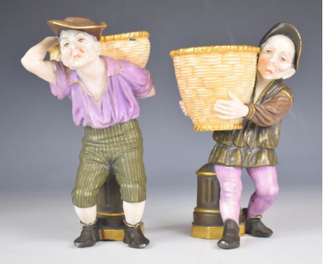 Royal Worcester pair of figural spill vases or sweetmeat dishes in the form of peasants carrying baskets, with puce marks, he